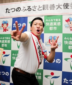 たつの市のふるさと親善大使に就任した田渕章裕さん。決めポーズを取ってＭ－１グランプリ優勝を誓った＝東京都千代田区
