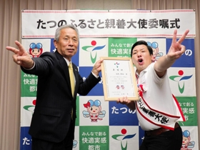 たつの市のふるさと親善大使に就任した田渕章裕さん（右）。山本実市長とポーズを取ってＭ－１グランプリ優勝を誓った＝東京都千代田区