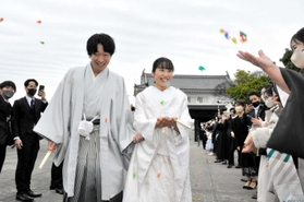 折り鶴シャワーで祝福される大塚飛人さんと里奈さん＝赤穂城跡