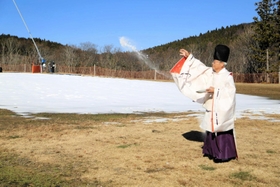 人工降雪機で降らせた雪の前でゲレンデを清める宮司＝神河町上小田
