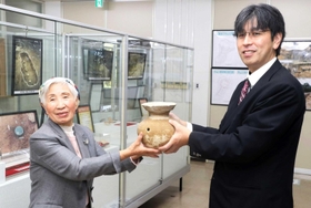 職員にはそうを手渡す中尾智香子さん＝上郡町郷土資料館