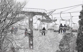 降りしきる雪でリフトのスキー客も銀世界に溶け込む＝宍粟市千種町西河内