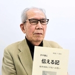 改訂した文集を手に平和への思いを語る松浦暁了さん＝たつの市内