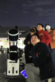 花北観望会で家族連れに星空を案内する井上毅さん（手前）＝花の北市民広場