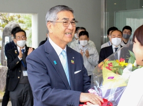 ２期目の初登庁となり、職員から花束を受け取る尾﨑吉晴町長＝福崎町南田原