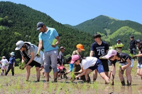 声をかけ合いながら苗を植えていく児童と留学生＝神河町長谷