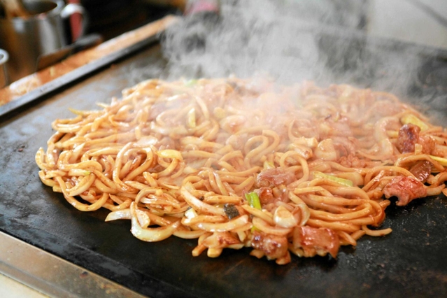 たれと具材をからめて仕上げる「津山ホルモンうどん」（ホルモン麺対決鳥取の陣実行委員会提供）