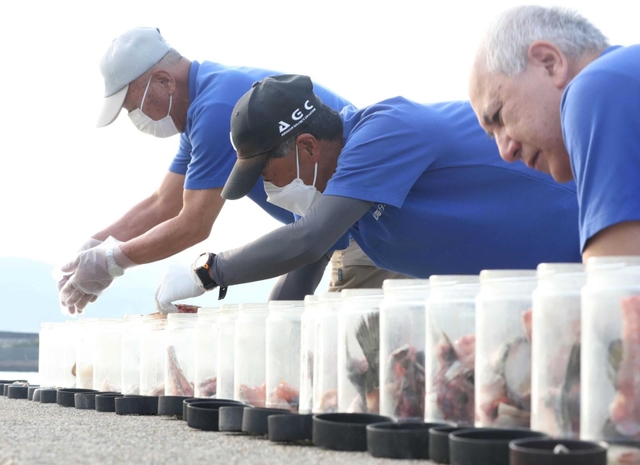 空き瓶に魚のあらを入れ、仕掛けを用意＝赤穂市中広（撮影・辰巳直之）