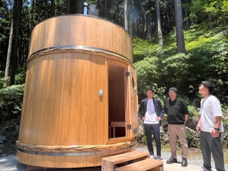 酒だる型サウナ「ｍｕ－ｓｕ」の前に立つ宍粟印の社員＝宍粟市一宮町東河内