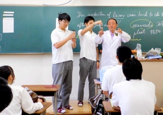 白衣を着て生徒と実験をする桝谷英樹校長（右）＝太子町糸井（太子高校提供）