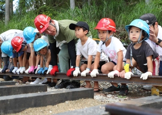 レールの敷設に協力する子どもたち＝フォレストステーション波賀（撮影・辰巳直之）