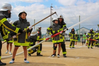 子どもたちに放水の仕方を教える福崎町消防団員＝福崎町西田原