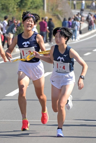 女子・龍野の３区松沼杏奈選手（左）からたすきを受け取る４区岡田優月選手＝丹波篠山市内（撮影・風斗雅博）