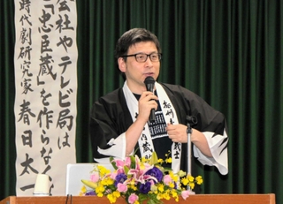 忠臣蔵グッズを身に付けて講演した時代劇研究家の春日太一さん＝赤穂市加里屋中洲３