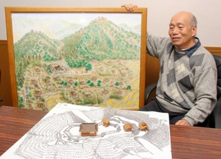 春日山城の往時の姿を復元図や模型で表現した木内内則さん＝福崎町八千種
