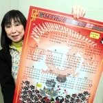 赤穂義士に見立てた黒猫がヌンチャクを振る「燃えよドラゴン」風のカレンダーとマエカワマサミさん＝赤穂市役所