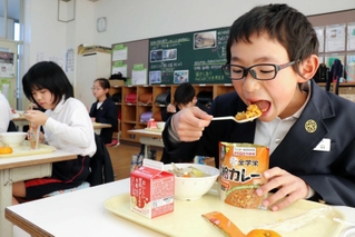 学校給食用の非常食「救給カレー」を食べる児童＝佐用町佐用、佐用小学校