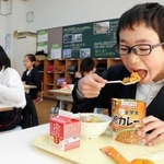 学校給食用の非常食「救給カレー」を食べる児童＝佐用町佐用、佐用小学校