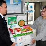 みなと銀行赤穂支店に寄せられた食品を高尾広志支店長（左）から受け取る、あこう子ども食堂の岩崎由美子さん＝赤穂市加里屋