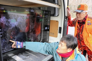ドローンで撮影した赤外線カメラの映像を確認する佐用郡猟友会の会員と佐用町職員＝佐用町長尾