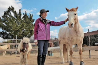 馬と触れ合い、心を癒やす「ハッピーホースファーム」を経営する香山かつ子さん＝岡山県和気町小坂