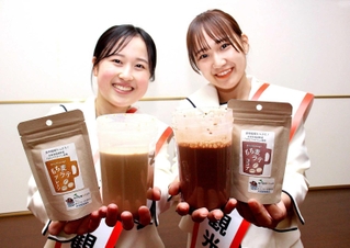 牛乳や豆乳に溶かして飲める商品「もち麦ラテ」をＰＲするふくさき観光大使の２人＝福崎町高岡
