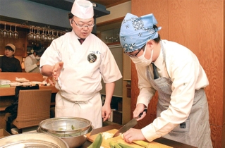 中嶋建二さんから野菜の下処理の仕方を教わる生徒＝姫路市魚町
