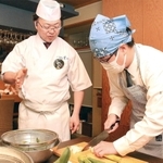 中嶋建二さんから野菜の下処理の仕方を教わる生徒＝姫路市魚町