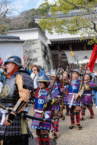 勝ちどきを上げ、城下町を進む龍野武者行列の一団＝たつの市龍野町