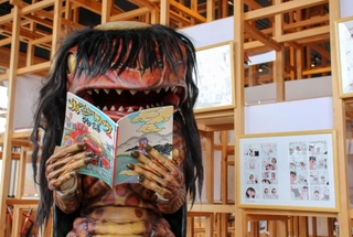 自身の日常が描かれた漫画本を読むガジロウ＝福崎町西田原