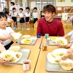 卵料理を味わう園児に「もっと卵を作ってね」と声をかけられ、笑顔を見せる田隅養鶏場の田隅博也取締役（右から３人目）＝いちかわ西こども園