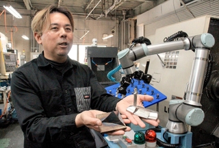 協働ロボットの力を借り、新商品開発に励む「ファイブ・ストレート」の品川太志さん＝市川町神崎