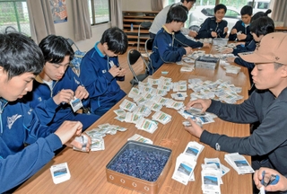ヒマワリの種を袋詰めする佐用高校の生徒ら＝林崎コミュニティセンター