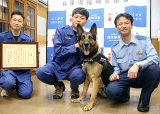 捜索開始からわずか１６分で行方不明者を発見した警察犬のムック号と村上警部補（左から２人目）＝福崎署