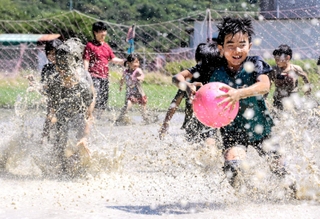 泥だらけになりながら休耕田を走り回る児童ら＝赤穂市高野