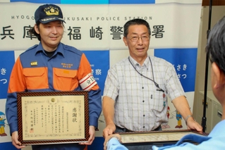 感謝状を受け取る牛尾一幸さん（右）と福崎町消防団西治分団長の木村竜也さん＝福崎署