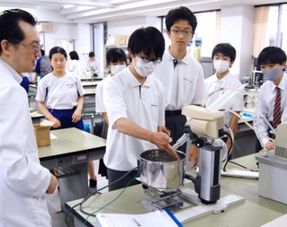 アルコールと香りの成分を分離する機械を操作する生徒たち＝上郡町光都３、県立大学付属中学校