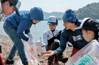 漂着したごみをよく確認して、海の環境問題について考える菅原真樹さん（右から２人目）と子どもたち＝赤穂市坂越
