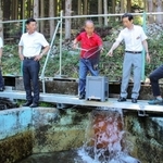 南あわじ市の守本憲弘市長（右から２人目）に養殖するヤマメを見せる長谷漁協の大和正美組合長（同３人目）＝神河町川上