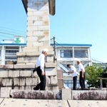 遺族会の会員らが慰霊碑に手を合わす様子を撮影する映像制作会社のスタッフら＝市川町東川辺