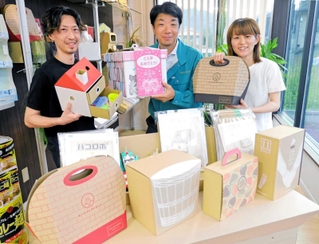 小倉優一社長（中央）が持つ「お祝いボックス」をはじめ、ユーパックが手がけた多彩な段ボール製品＝たつの市神岡町大住寺