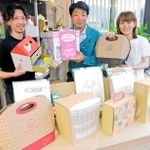 小倉優一社長（中央）が持つ「お祝いボックス」をはじめ、ユーパックが手がけた多彩な段ボール製品＝たつの市神岡町大住寺