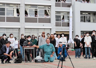 赤穂高校定時制の生徒らが作ったロケットを打ち上げる植松努さん（中央）ら＝赤穂市海浜町、赤穂高校