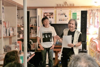 平和音楽祭で、ビートルズの曲を紹介するビートルズ文化博物館の岡本備館長（右）＝赤穂市加里屋