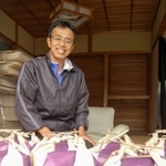 ２、３歳児健診受診者宅に送る特別栽培の「タガメの里自然米」を前に話す笹山和朗さん＝上郡町高山