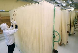 長いはしで均等にほぐされ、乾燥されるそうめん＝姫路市安富町名坂