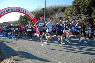 号砲を合図に一斉にスタートするハーフマラソンの選手たち＝御津運動場