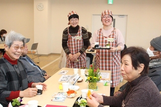 笑顔でお茶を運ぶ「ひと花」のメンバー（中央の２人）＝神河町粟賀町