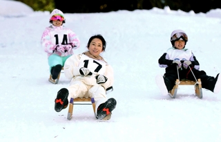 雪上を滑走する木ぞりレースの参加者＝宍粟市波賀町戸倉、ばんしゅう戸倉スキー場