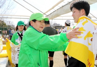 完走したランナーにタオルをかける尾上あい子さん（中央）＝姫路城三の丸広場
